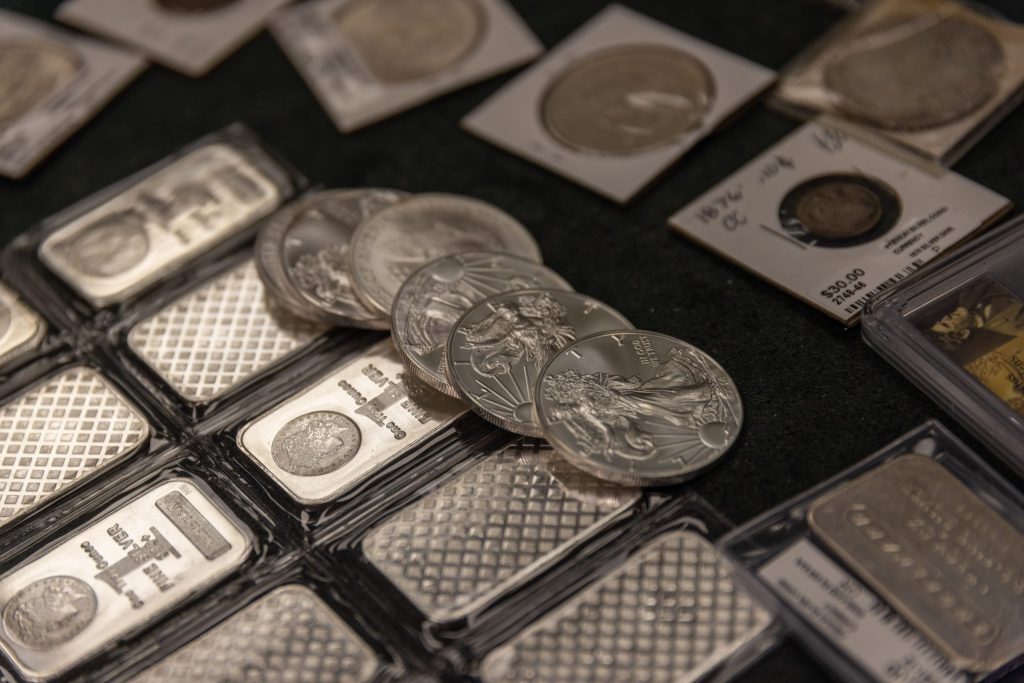American Silver Eagles, silver bullion bars and collectible coins arranged in a showroom display.