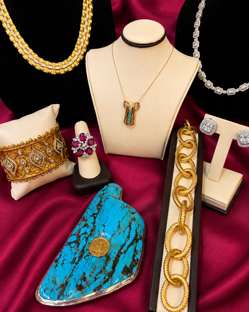 Necklaces, pendants, earrings, and other estate jewelry arranged on display stands.