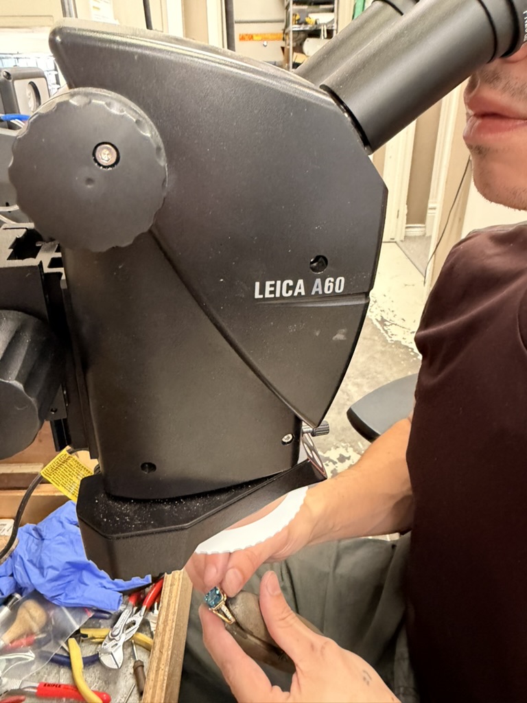 Jake examines a gemstone ring using the Leica microscope at the jeweler’s workbench.