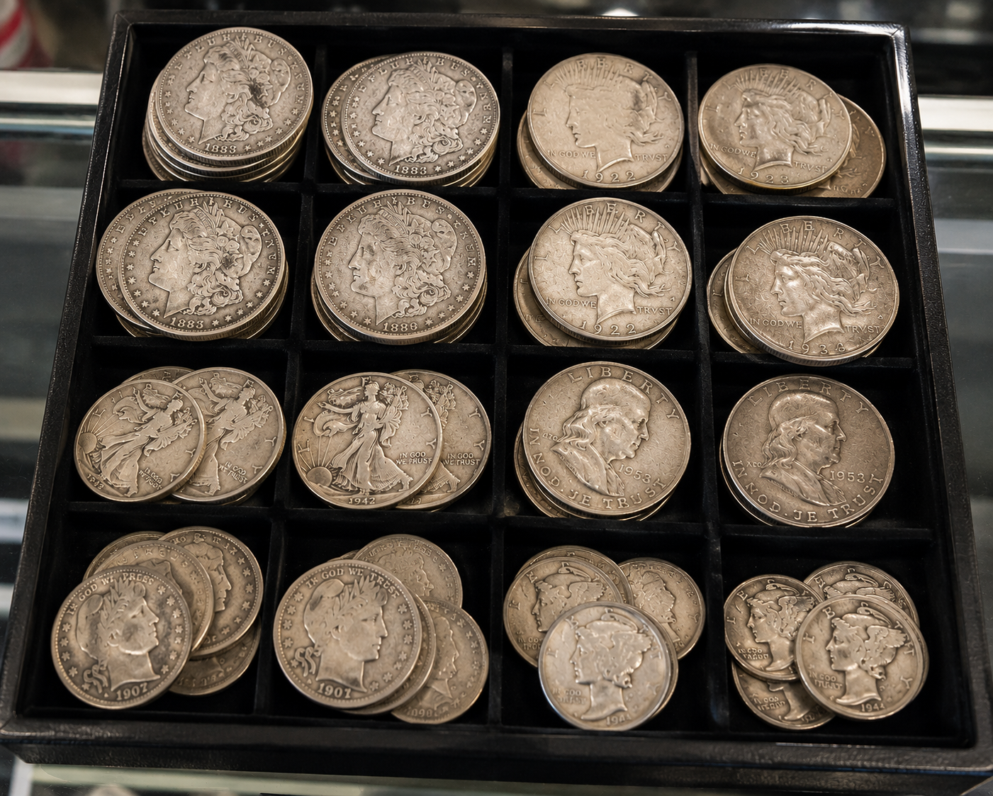 Rows of collectible coins arranged in a black display tray.