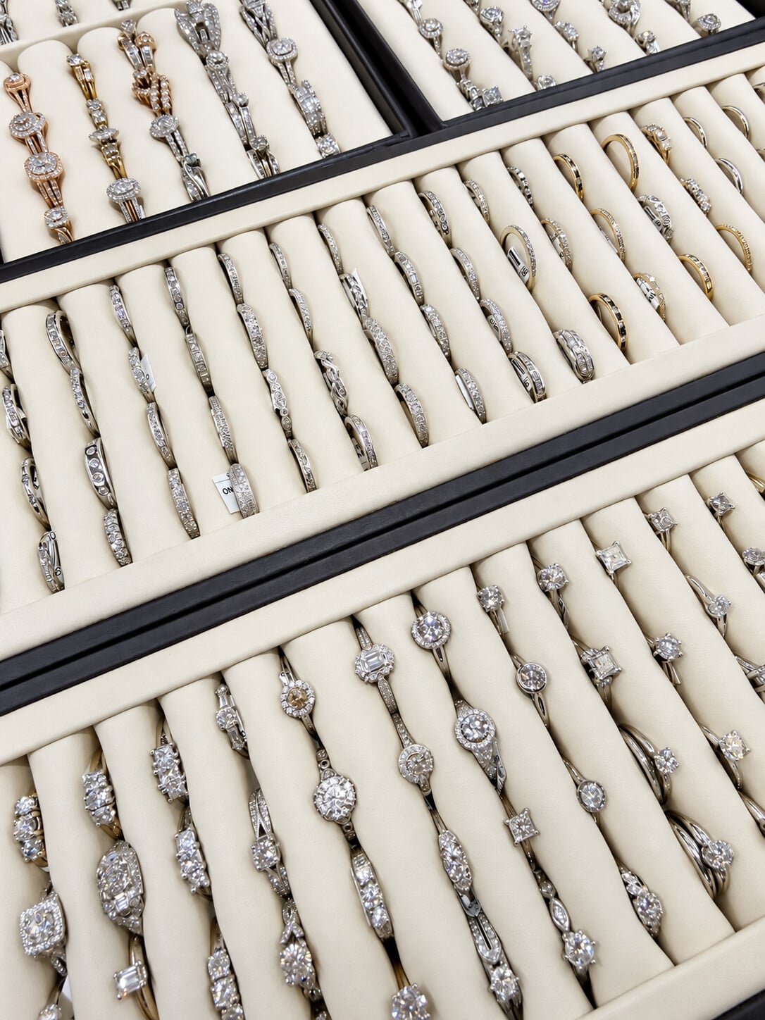 Women’s wedding bands, including curved and stone-set styles, displayed alongside engagement rings.